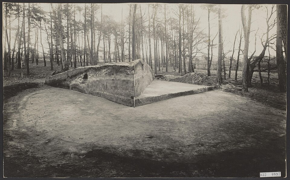 Een grafheuvel opgegraven met de kwadrantenmethode, 1927. De twee staande wanden in het midden zijn de profielen waar de methode om draait: daarin lees je de opbouw af, terwijl de vlakken ernaast laten zien wat er in de grond lag. Waar deze heuvel lag staat er niet bij – de catalogus houdt het op het Noordse Veld bij Zeijen.